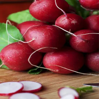 a bunch of fresh cherry belle radishes on a cutting board with some sliced