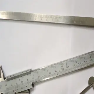 a close-up image of two measuring tools: a caliper and a protractor, used for precise measurements in various fields