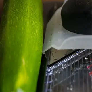 a close-up of a mandoline slicer with a zucchini
