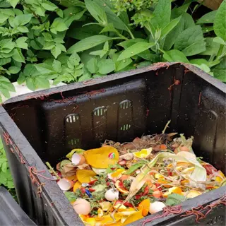a compost bin filled with organic waste in a garden setting