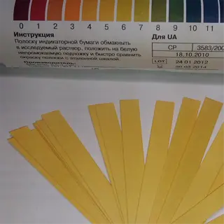a container of ph test strips with a color chart and instructions in russian