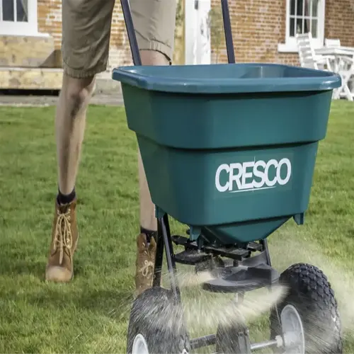 a cresco lawn fertilizer spreader spreading grass seed on a lawn