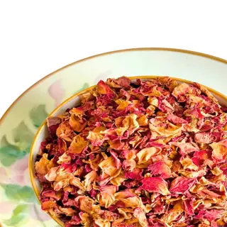 a cup filled with dried rose petals, used for culinary purposes like tea or garnish