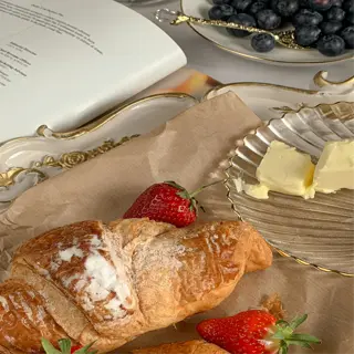 a french breakfast with croissants, strawberries, and a side of butter
