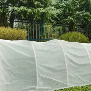 a frost cloth tunnel protecting plants in a garden