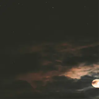 a glowing moon shines through dramatic clouds, with faint stars visible in the night sky