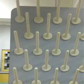 a laboratory drying rack with multiple pegs for holding glassware