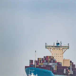 a large container ship with stacked containers on deck, showcasing container adaptations for maritime transport
