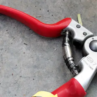 a pair of felco 7 bypass pruners with red handles and a curved cutting blade
