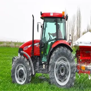 a red tractor with a fertilizer spreader machine attached, spraying on a green field
