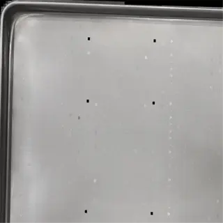 a silver perforated tray with evenly spaced holes