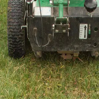 a slit seeder machine on a grassy lawn