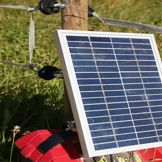 a solar-powered electric fence kit in a grassy field