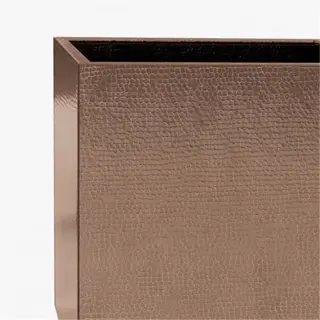 a square copper planter with a textured surface