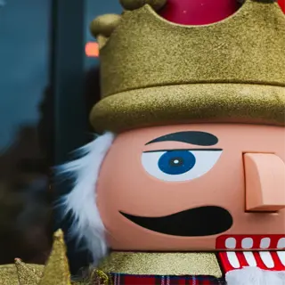 a traditional nutcracker with a gold crown, blue eyes, and a red plaid outfit