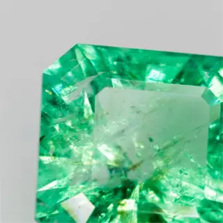 a vibrant green emerald gemstone with a sparkling, faceted surface