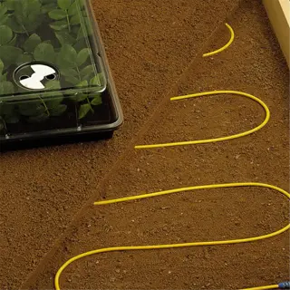 a wooden planter bed with yellow soil heating cables and plant trays
