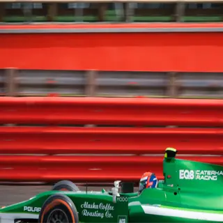 alaska f1 racing car on track with 'caterham' and 'alaska coffee roasting co.' branding