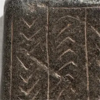 an ancient stone object with intricately carved lines, possibly a seed spacer template