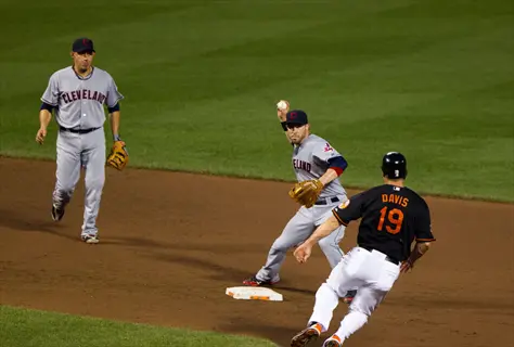 baseball double play: cleveland infielder fields ball near second base as orioles' chris davis slides during game action