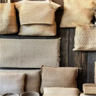 burlap plant covers and woven baskets displayed on a wooden wall
