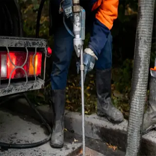 clogged drainage holes: workers using a vacuum to clear a blocked storm drain