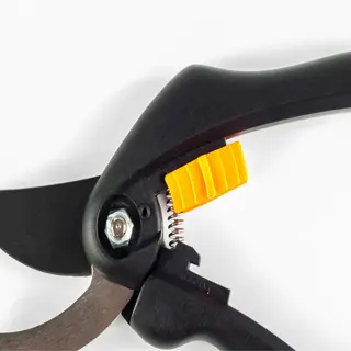 close-up of a black pruning shear with an orange safety lock