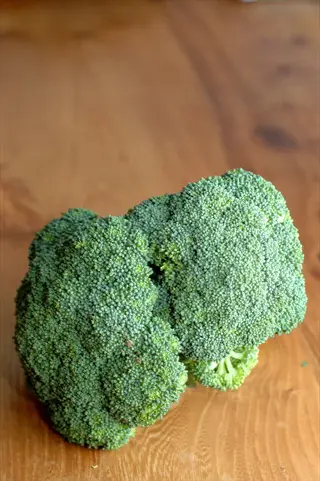 close-up of broccoli tight buds on a wooden surface
