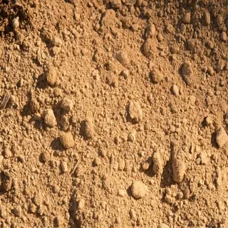 close-up of compacted clay soil with visible pebbles