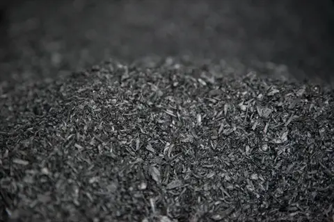 close-up of dark, porous biochar soil amendment material. the charcoal-like substance with visible fragments enhances soil fertility and water retention in sustainable gardening