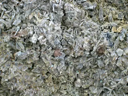 close-up of gypsum soil amendment showing pale crystalline particles and granular texture