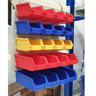 colorful wall-mounted storage bins garage organizer: red, blue, and yellow plastic containers in a metal rack. ideal for tools, hardware, or supplies in a workshop/garage setting with concrete floor
