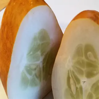 cross-section of a lemon cucumber showing its unique light green flesh and seeds