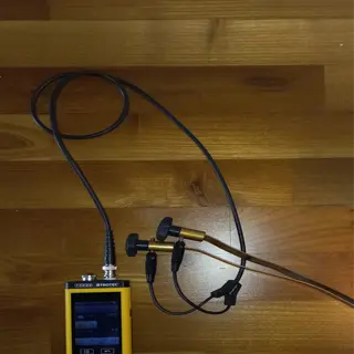 digital moisture meter with probe on wooden floor