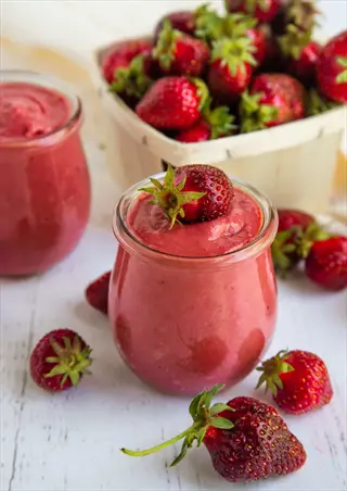 glass jar of albion strawberry ripe smoothie with fresh albion strawberry ripe surrounding it and in a basket