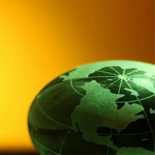 green globe with detailed continents, set against a warm orange backdrop