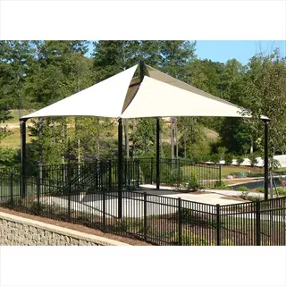 large garden shade cloth canopy providing coverage over a paved area in a landscaped outdoor space with trees and fencing