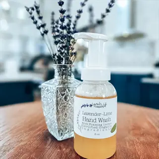 lavender-lime hand wash bottle with pump dispenser showing soap water solution, on wooden table with dried lavender in glass vase