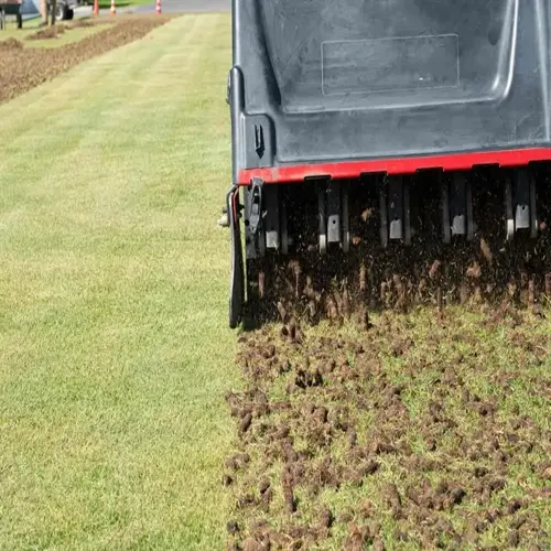 lawn aeration machine removing soil plugs from a grassy field
