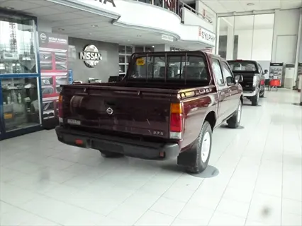 maroon nissan bravado pickup truck displayed in a car showroom with visible vehicle details and branding