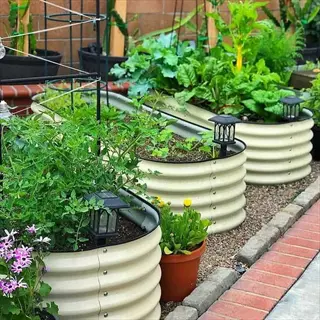 metal garden bed holes with thriving plants, solar lights, and gravel pathways. these corrugated metal raised beds demonstrate metal bed modification for urban gardening