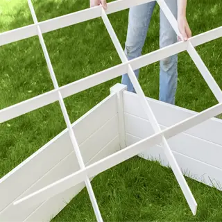 person assembling a white pvc garden grid for raised bed