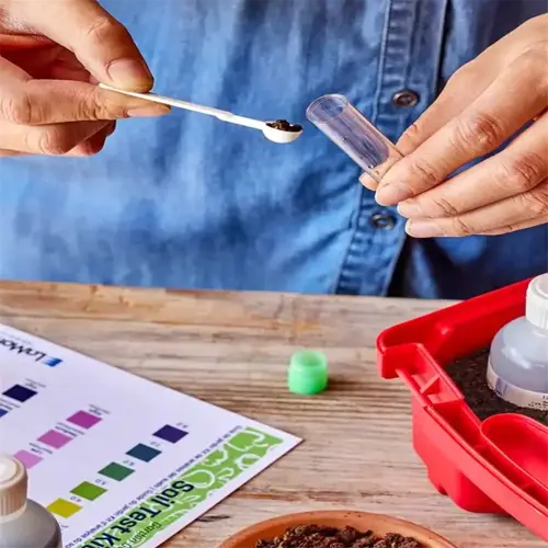 person using a soil test kit to test soil in a garden