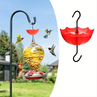 red umbrella-shaped ant moat above a swirled glass hummingbird feeder with hummingbirds in a garden