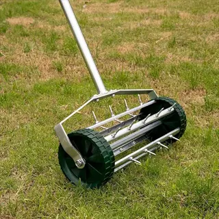 rolling spike garden aeration tool on a grassy lawn