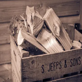 sepia-toned image of a wooden crate labeled s. jeeps & sons, filled with firewood