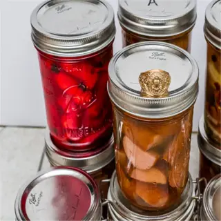 several glass jars with lids containing canned food, demonstrating canning basics
