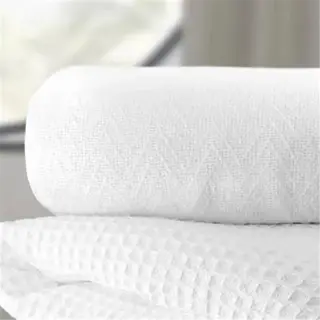 stack of white thermal blankets with a waffle weave texture