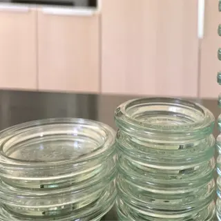 stacks of clear glass fermentation weights on a kitchen countertop
