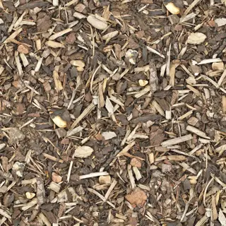 textured surface of natural wood chip mulch: mixed brown and gray fragmented wood pieces with varied sizes, scattered on soil. note: this is classic wood chip mulch for landscaping, distinct from other organic mulches